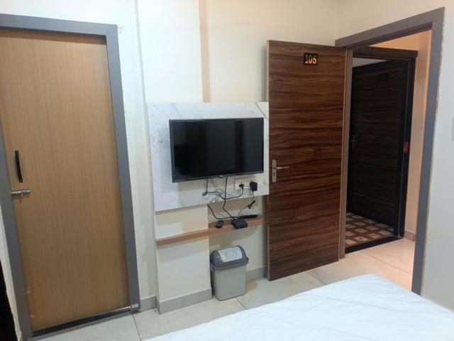 a room with a television on a wall with a door at Hotel Jayaswal INN in Bharbharia