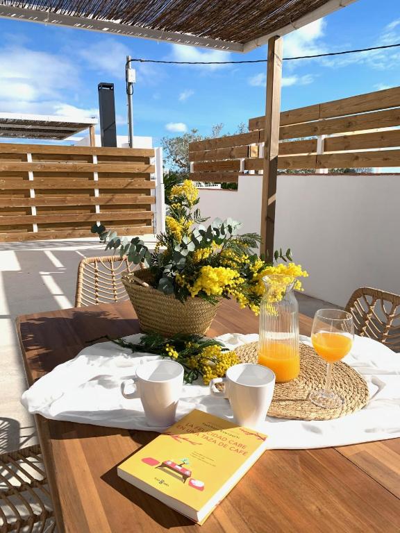 a table with two glasses of orange juice and flowers at Masia CHOPO in L'Aldea