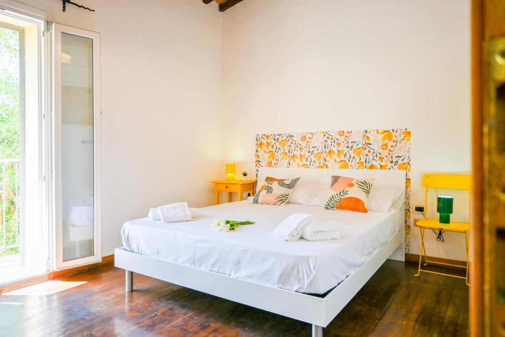 a bedroom with a bed with white sheets and orange pillows at InnPisaRentals - Cozy Flat by the Airport in Pisa