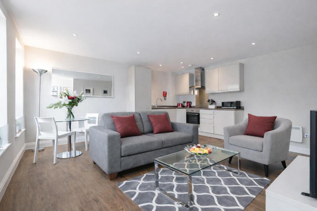a living room with a couch and chairs and a table at Roomspace Serviced Apartments - Trinity House in Reigate