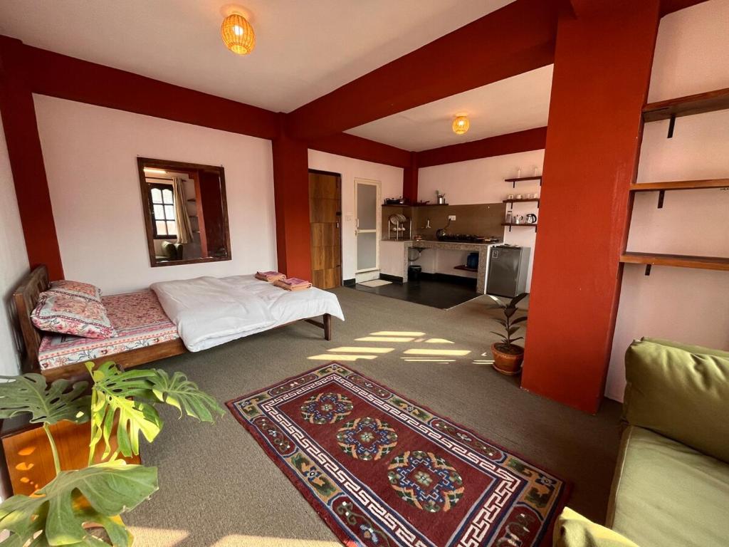 a living room with a bed and a kitchen at Avalokiteśvara Āvāsa in Kathmandu