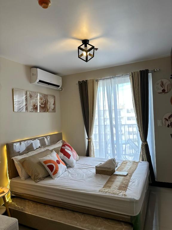 a bedroom with a large bed with a window at staycaSHAWN studio in Lapu Lapu City