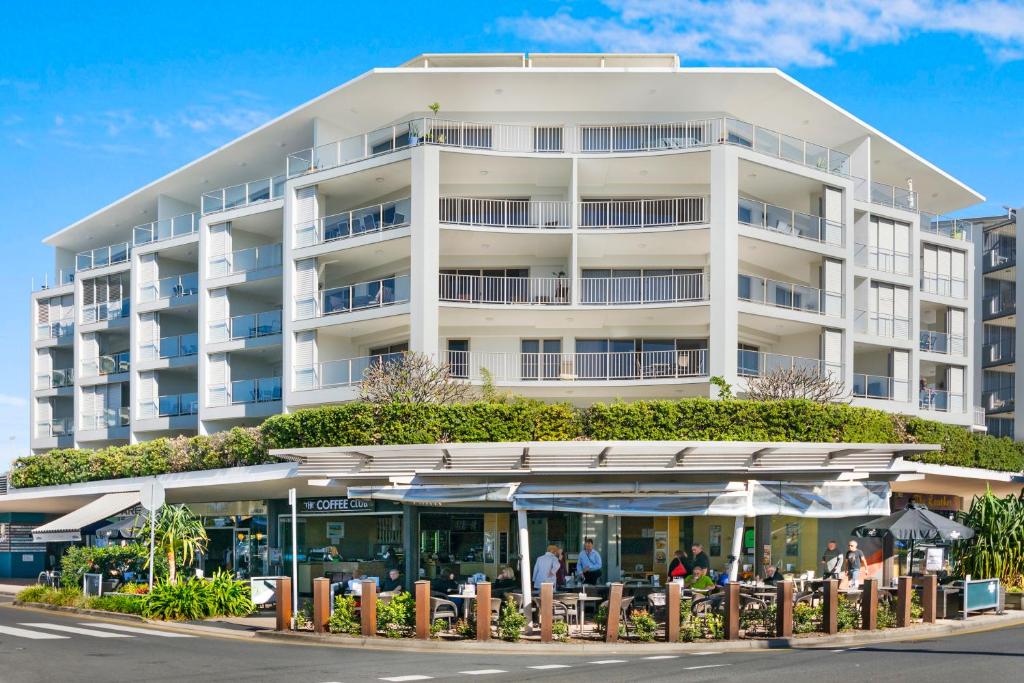 a large white building with people standing in front of it at Rovera Apartments in Maroochydore
