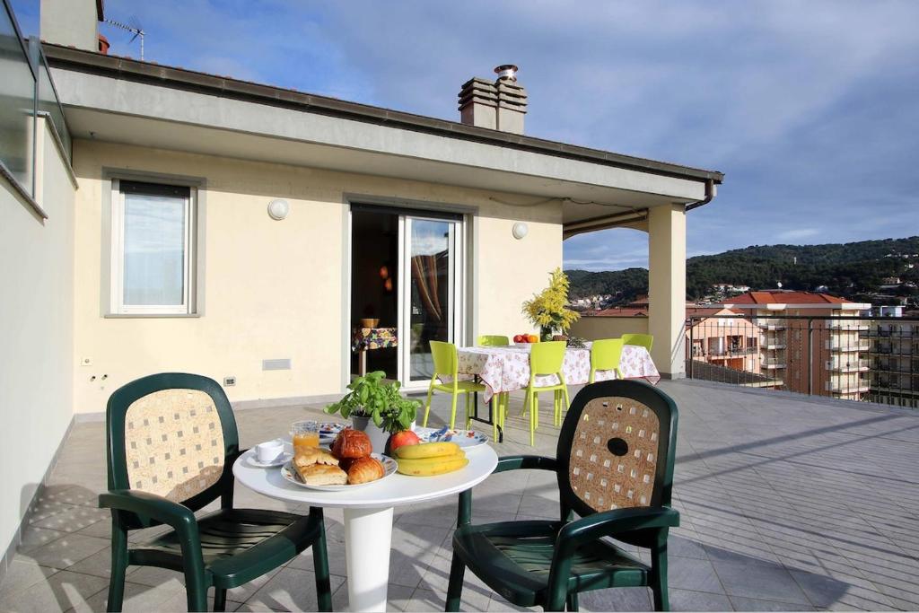 a patio with a table and chairs on a balcony at WI-RO Carminati - Mare e relax in Marina di Andora