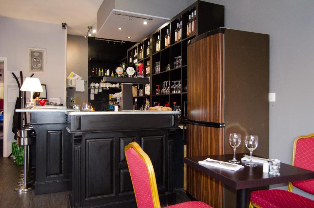 un bar in un ristorante con tavolo e sedie di L'Atrium a Béthune