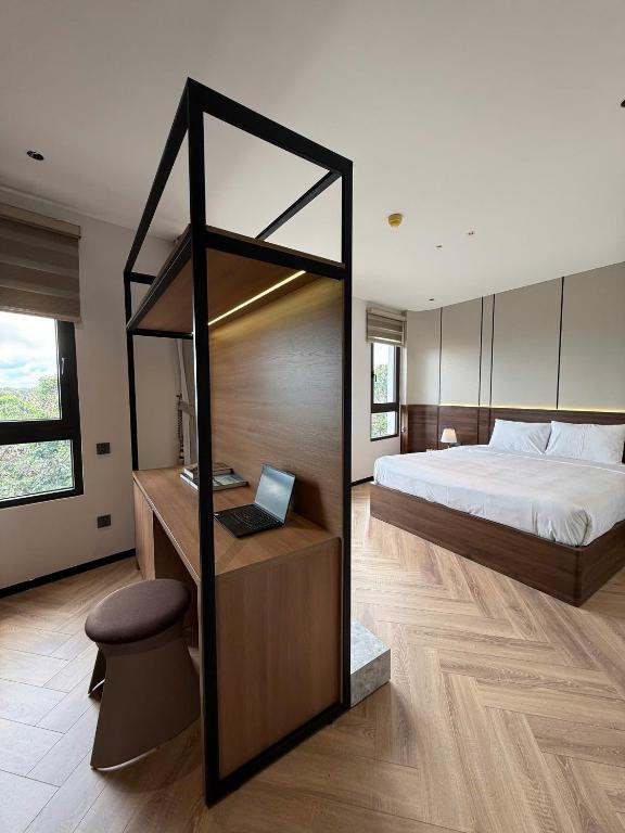 a bedroom with a bed and a desk with a laptop at Ama Retreat in Buôn Enao