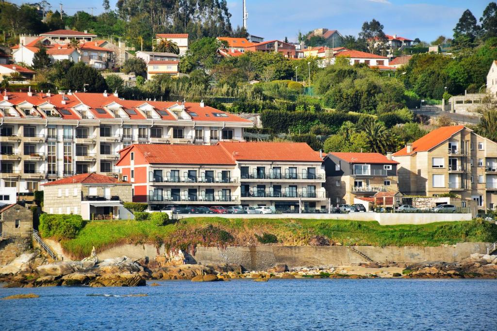 a group of houses on a hill next to the water at Apartamento Mardevela in Sanxenxo