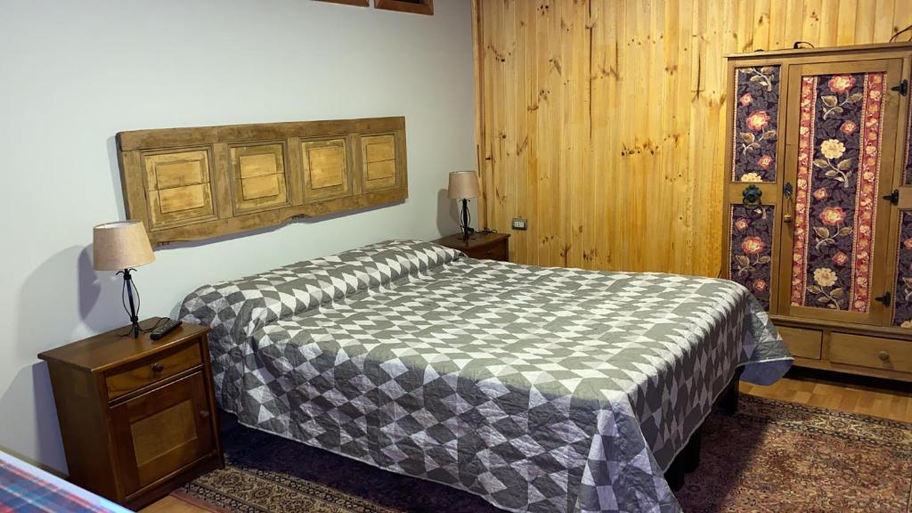 a bedroom with a bed and a wooden wall at Hermoso Loft Amoblado Sector Oriente Talca in Talca