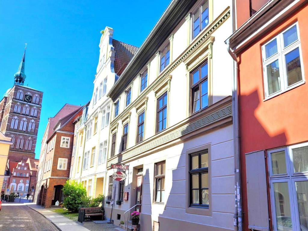 a row of buildings on a street with a clock tower at Altstadthaus Stralsund Külpstraße 11 in Stralsund