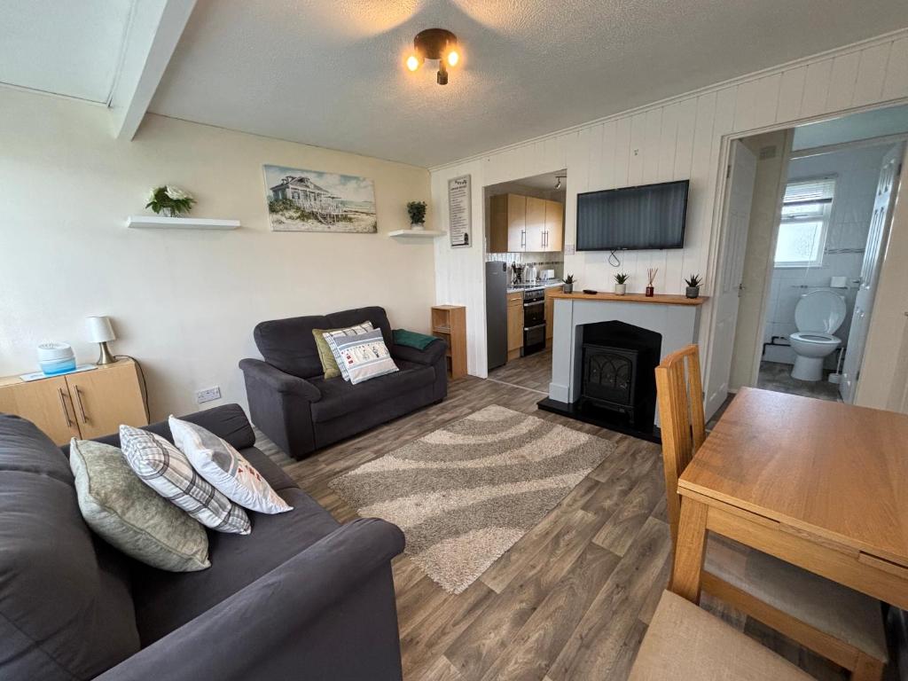 a living room with a couch and a table at 192, Two bed newly refurbished chalet on Sund0wner Holiday Park - Sleeps 5, pet friendly - Includes electricity, bed linen and towels - Entertainment options close by in Hemsby
