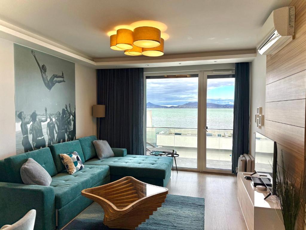 a living room with a blue couch and a view of the ocean at LakeSightHome in Fonyód
