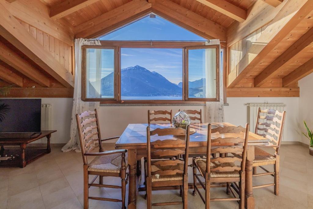 a dining room with a table and chairs and a large window at Il Nido sul Lago in Perledo