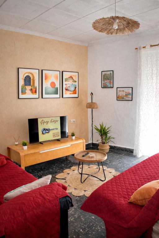 a living room with a red couch and a tv at Casa caloret -Playa y centro a 2 min - 1ªPlanta in Vinarós
