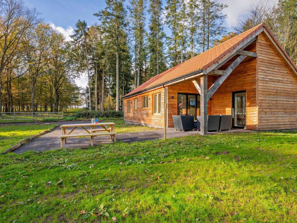 a wooden cabin with a picnic table and a bench at 2 Bed in Kings Lynn oc-96048 in Middleton