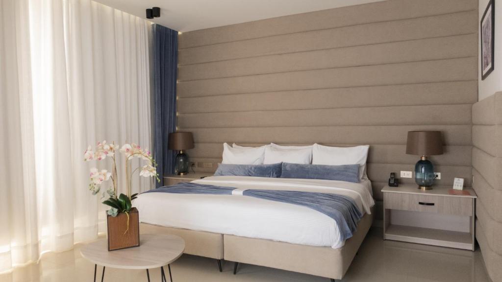 a bedroom with a king sized bed and a table at Ceibo Real in Portoviejo