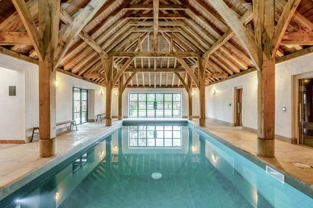 an indoor swimming pool with a wooden ceiling at 5 Bed in Kings Lynn oc-96250 in Clenchwarton