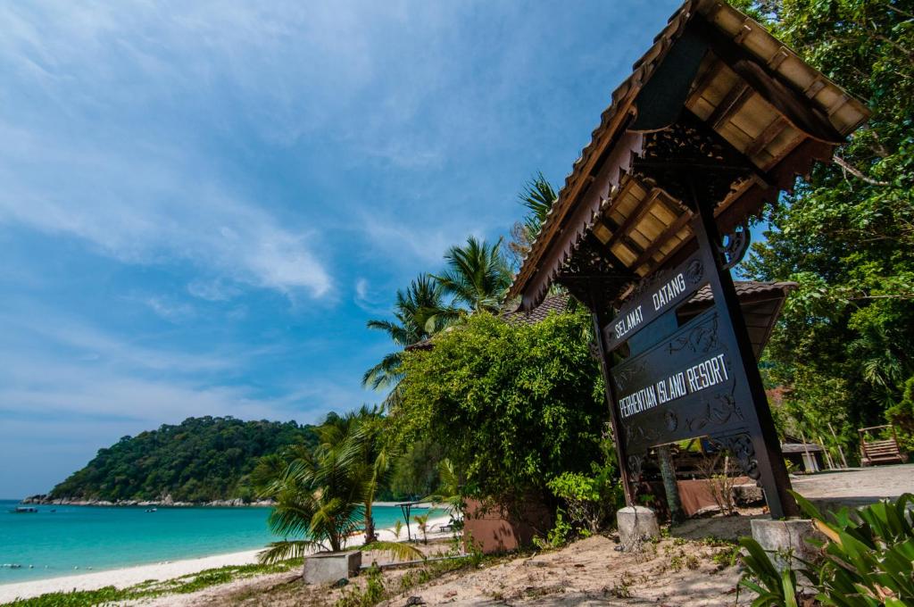 a sign on a beach near the ocean at Perhentian Island Resort in Perhentian Islands
