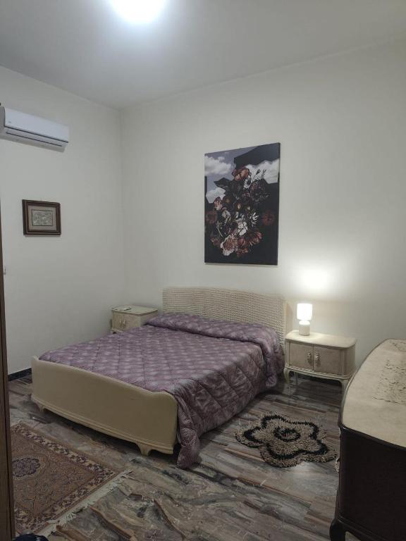 a bedroom with a bed and a painting on the wall at Bella Reggio in Reggio di Calabria
