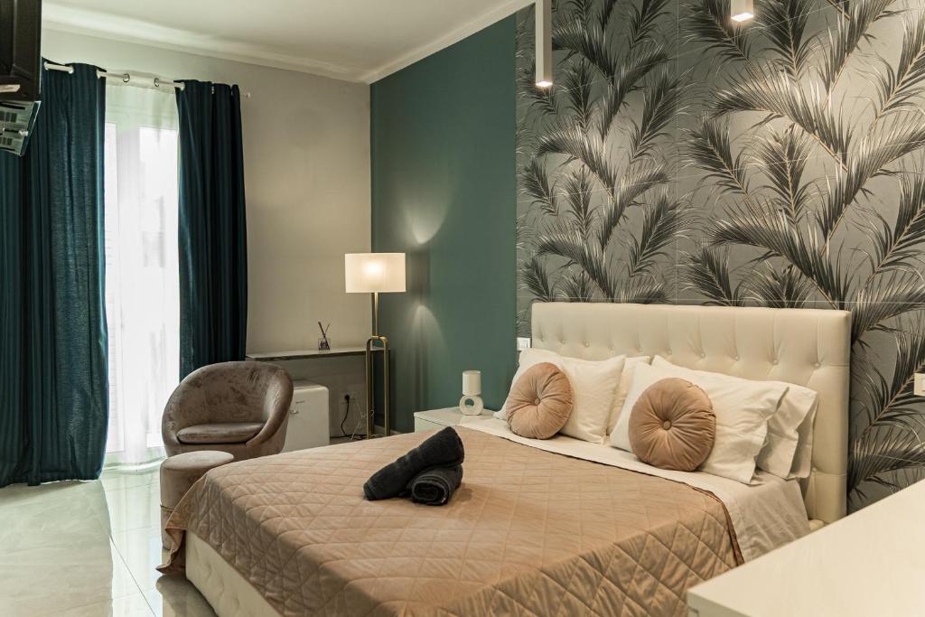 a bedroom with a large bed with a large leaf wallpaper at Palazzo Margò - Private Luxury Palace with Sea View in Mola di Bari