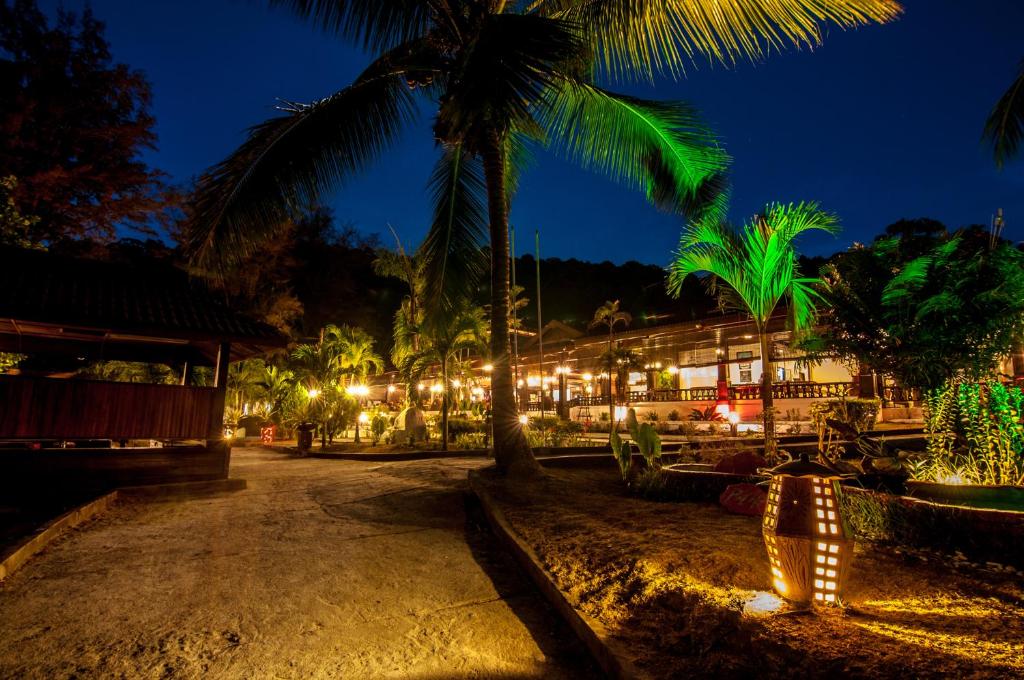 a resort lit up at night with palm trees and lights at Perhentian Island Resort in Perhentian Islands