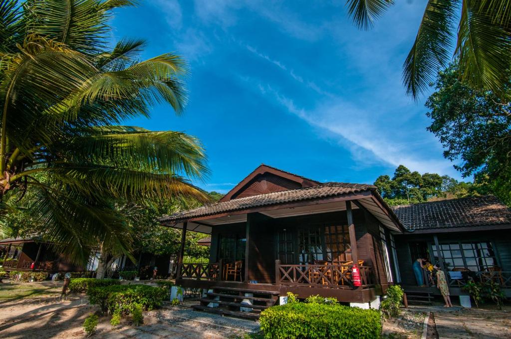 a house with a palm tree in front of it at Perhentian Island Resort in Perhentian Islands