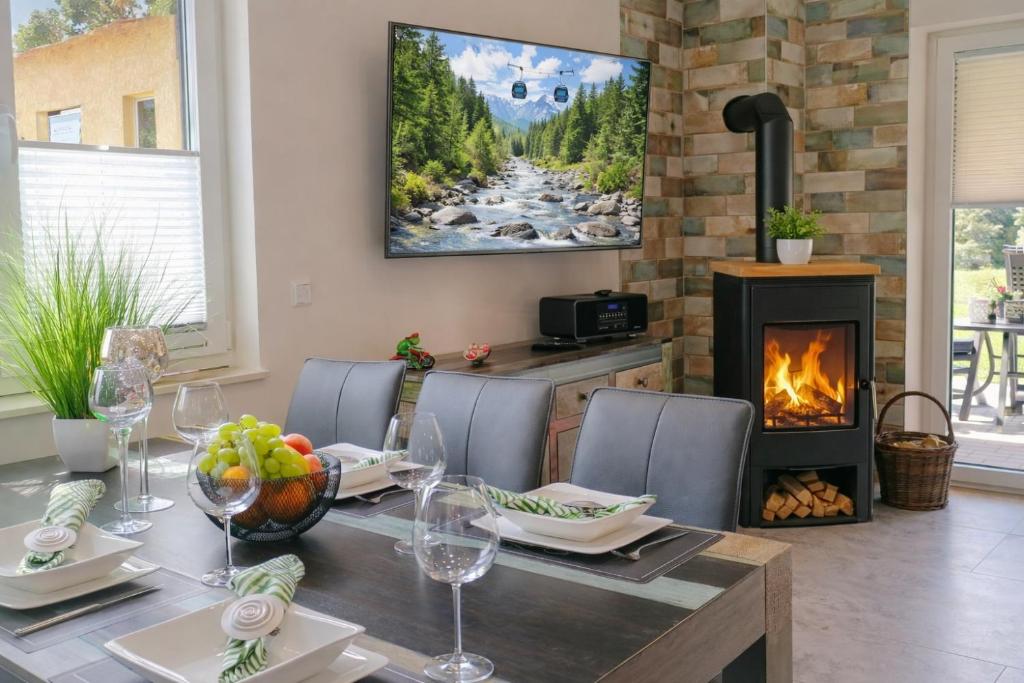 a dining room with a table and a fireplace at Premium-Plus-Ferienhaus Skadi I in Hasselfelde