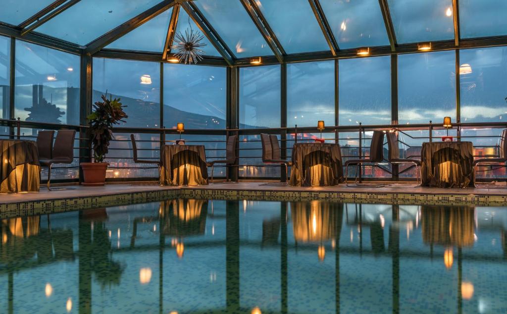 a swimming pool in a building with glass walls at Hotel Arka in Skopje