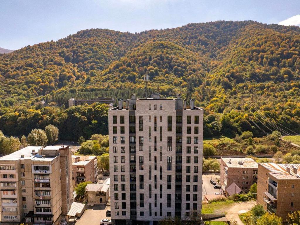 a tall building in front of a mountain at Apartment in Verin Apart hotel in Dilijan in Dilijan