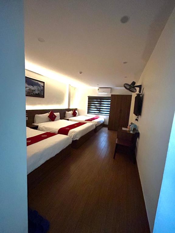 a hotel room with two beds and a television at OnMe in Sapa