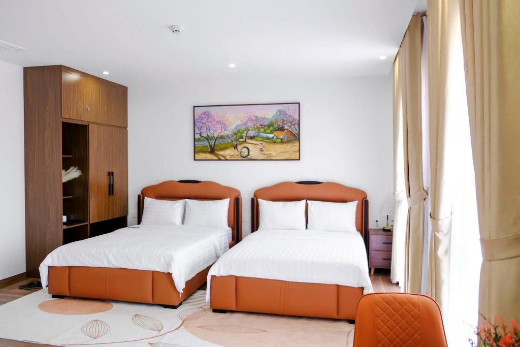 a bedroom with two beds and a painting on the wall at KHEM BEACH Hotel in Phú Quốc