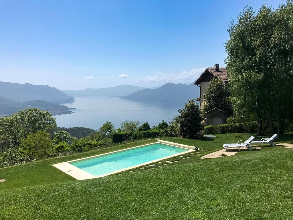 a swimming pool on a lawn with a view of the water at Villa Tirolese in Due Cossani