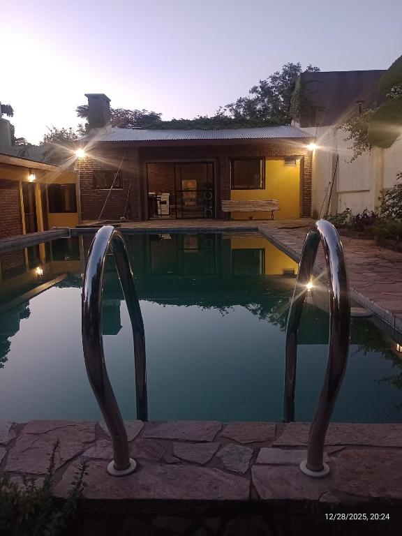 a swimming pool with two metal gates in front of a house at Ye muá, ye tuá in City Bell
