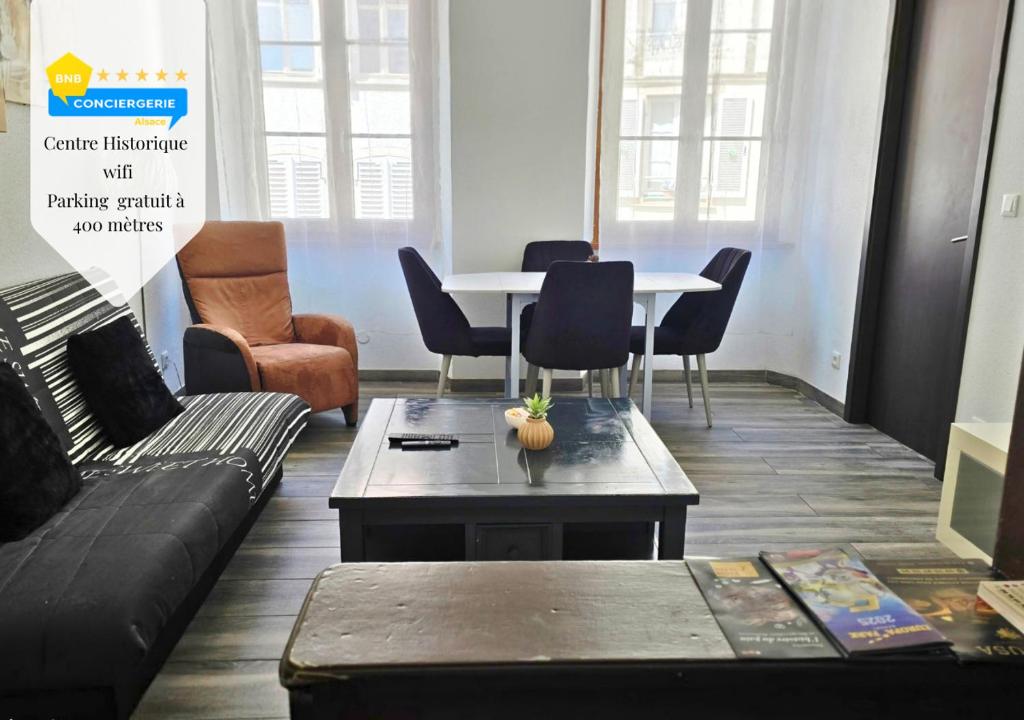 a living room with a couch and a table and chairs at La Petit Clé - Centre Ville in Sélestat