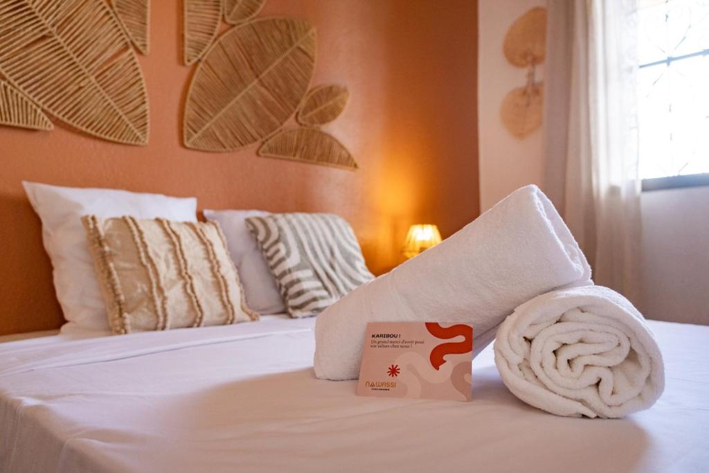 a hotel room with a white towel on a bed at T4 Oasis tropicale x Nawassi in Pamandzi