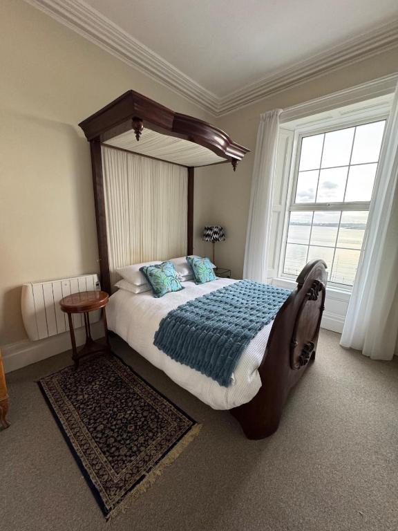 a bedroom with a large bed and a large window at Anns Sea View Suite in Cobh