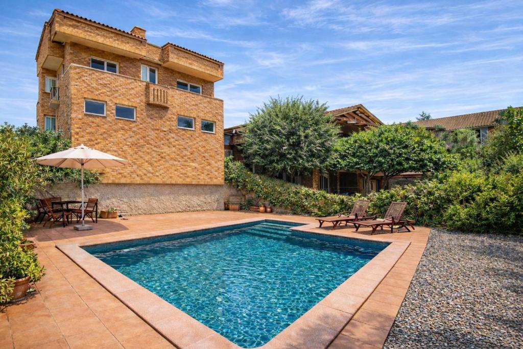 a swimming pool in the backyard of a house at Nature & Tranquility only 25km from Barcelona in Torrelles de Llobregat