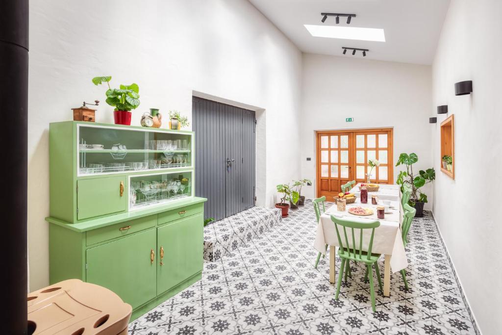 eine Küche mit grünen Schränken und einem Tisch mit Stühlen in der Unterkunft Sobe Rafut in Nova Gorica