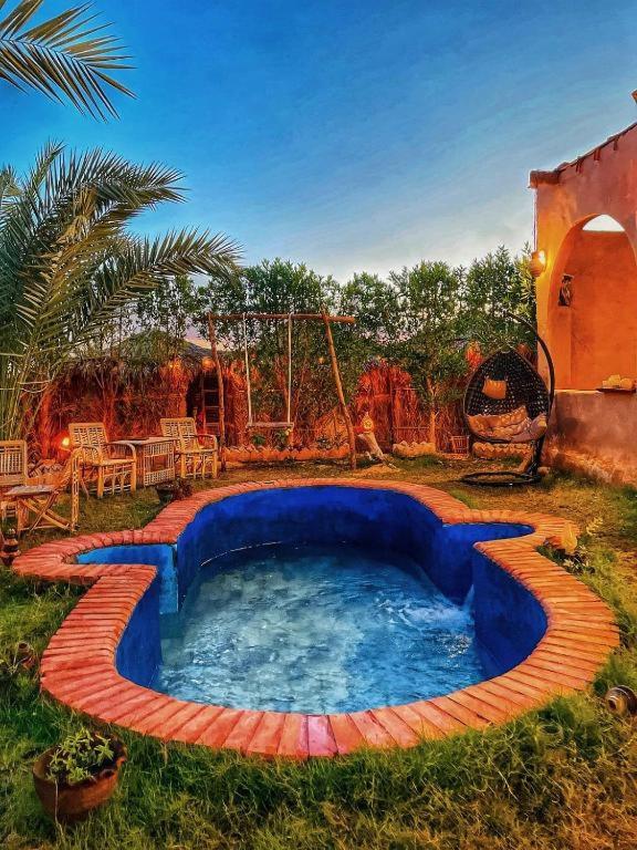 a swimming pool in a yard with a playground at The Green Mirage free pickup in Siwa