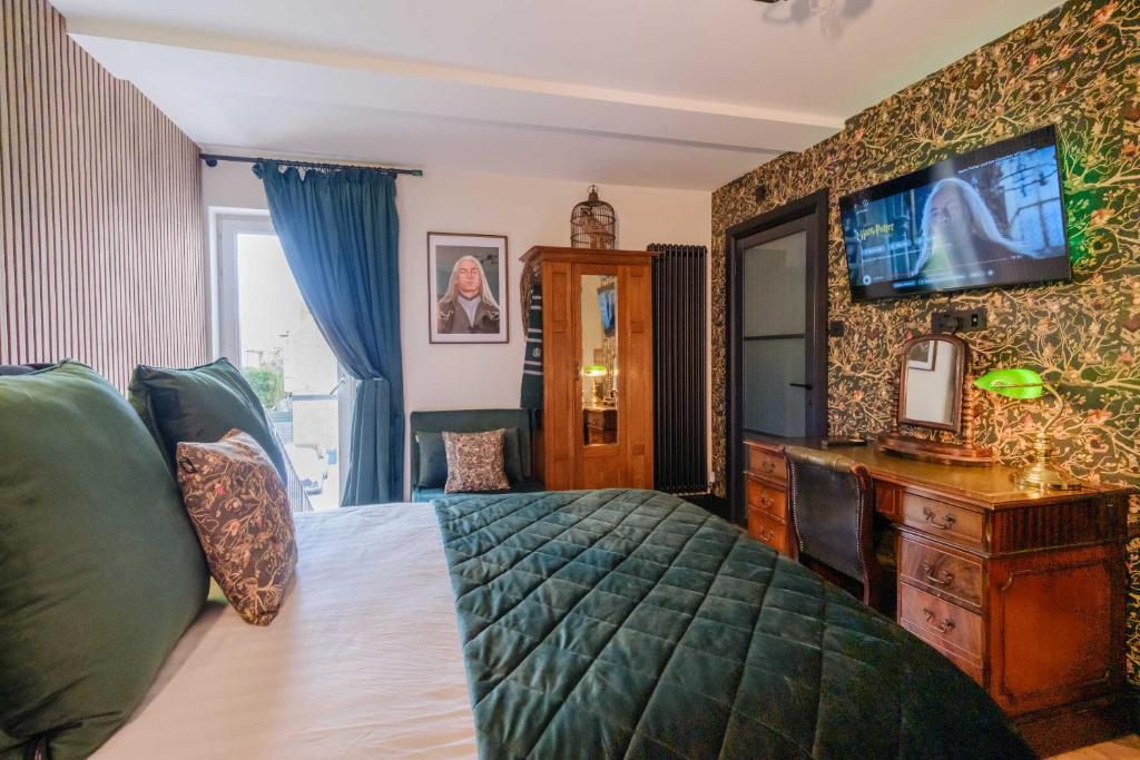 a bedroom with a bed and a tv on a wall at Ricky Road Guest House in Watford