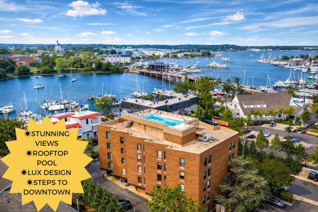 a view of a marina with a building and a sign at Luxury Rooftop Pool & Dock Steps to Downtown in Annapolis
