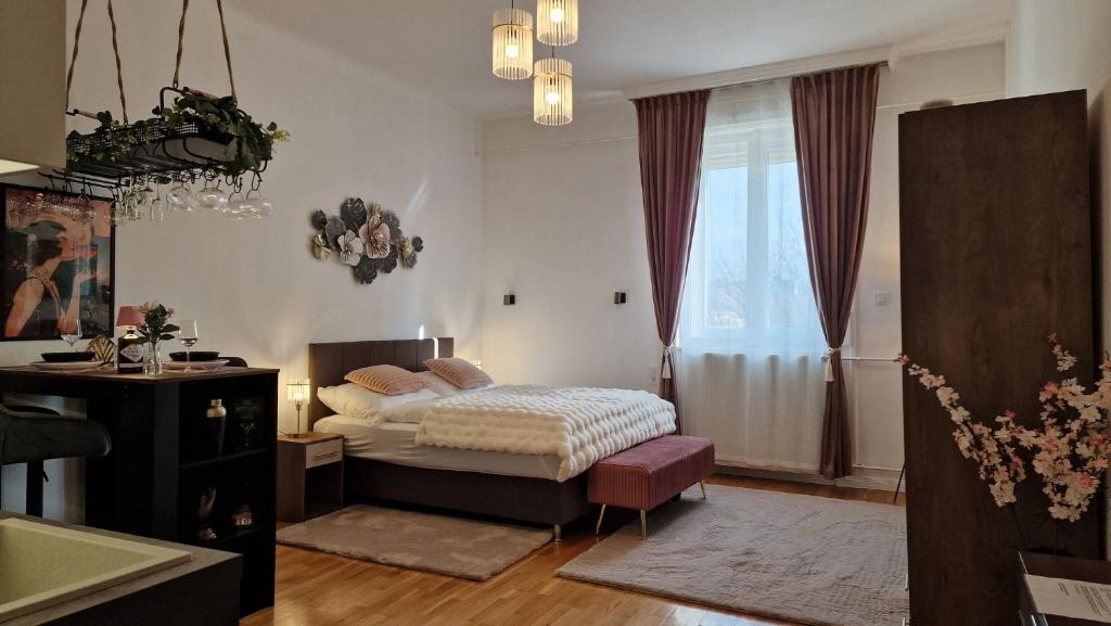 a bedroom with a bed and a window at Boudoir-Art Studio Apartment in Debrecen