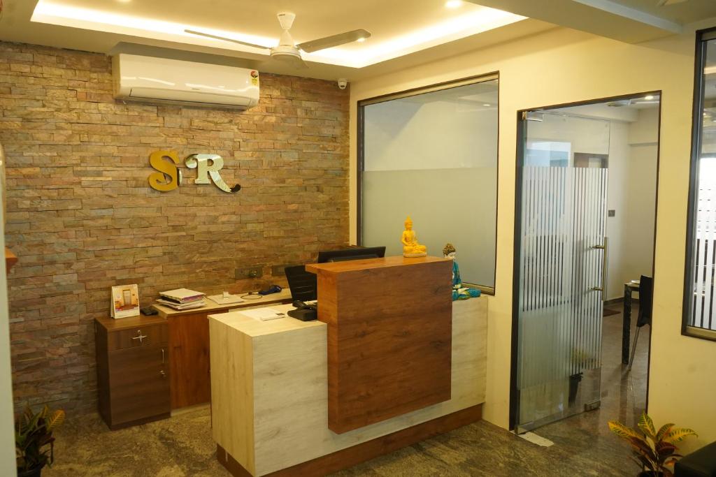an office with a reception desk and a brick wall at Sesha Residency in Chennai