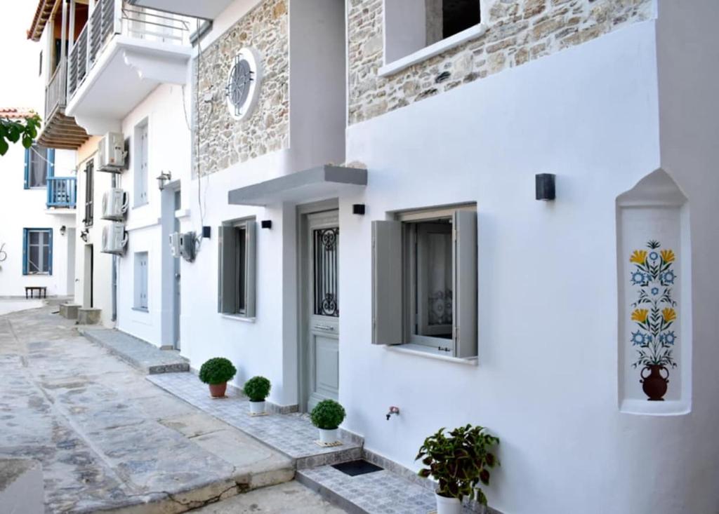 a street with white buildings and potted plants at Stella's House in Skopelos Town