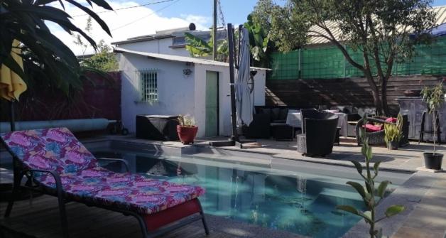 a chair sitting next to a swimming pool at La Kaz Zarlor in Saint-Paul