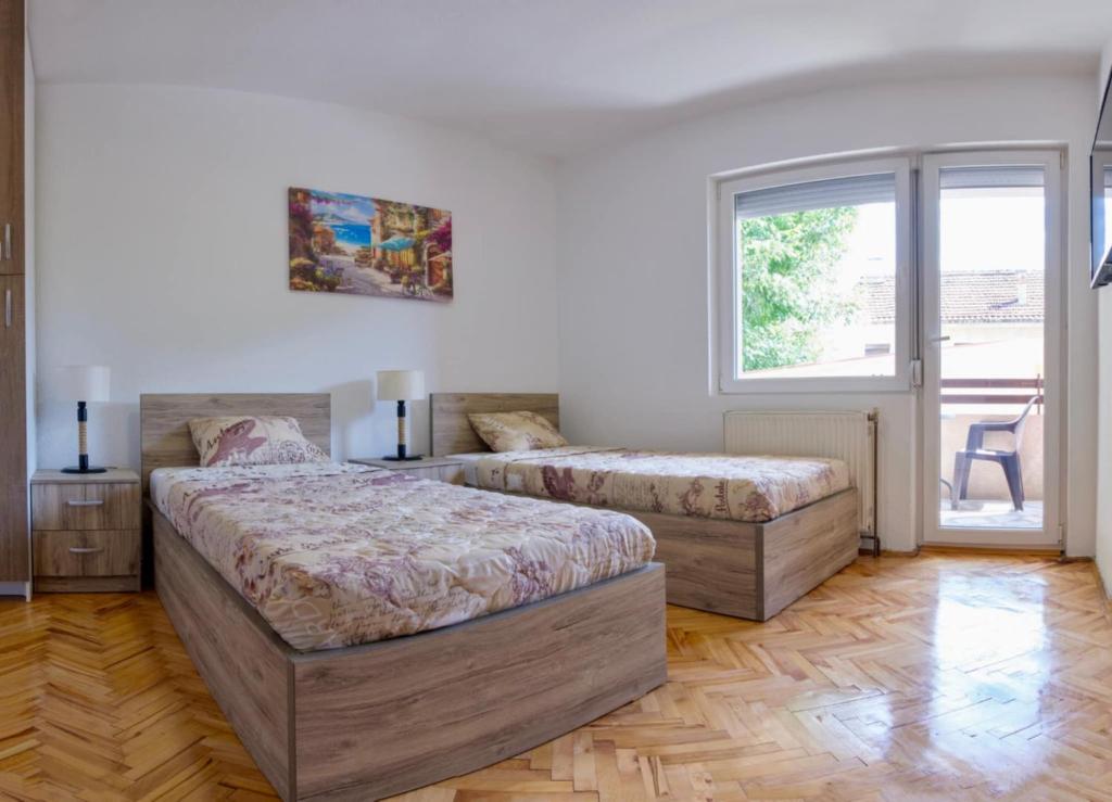 a bedroom with two beds and a window at Garden Hostel in Skopje