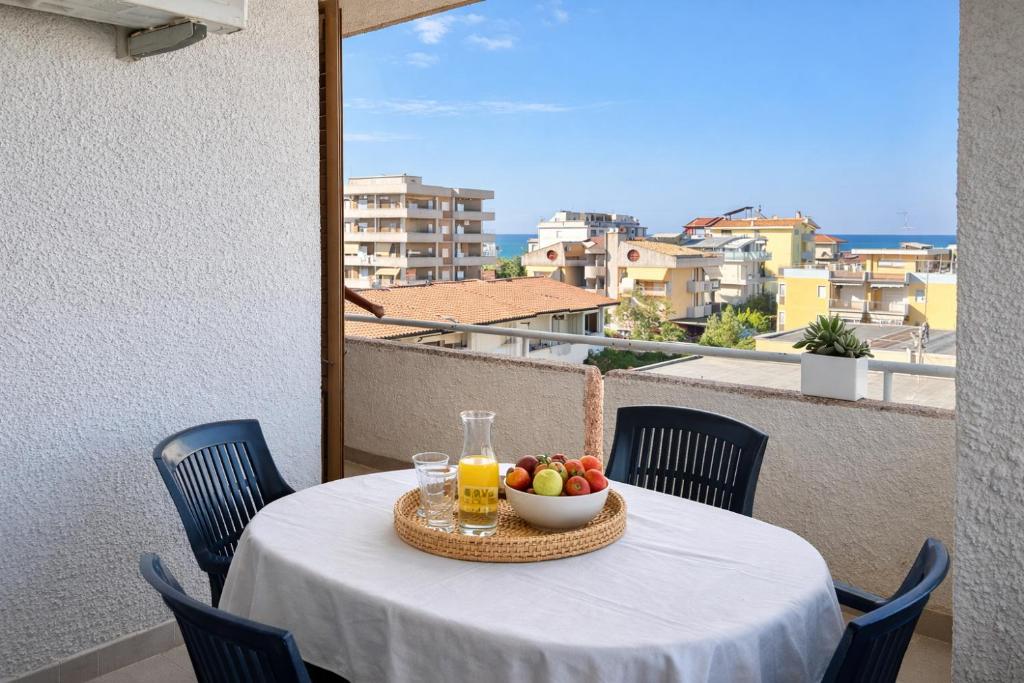 a table with a bowl of fruit and juice on a balcony at Dimora del Sole in Vasto