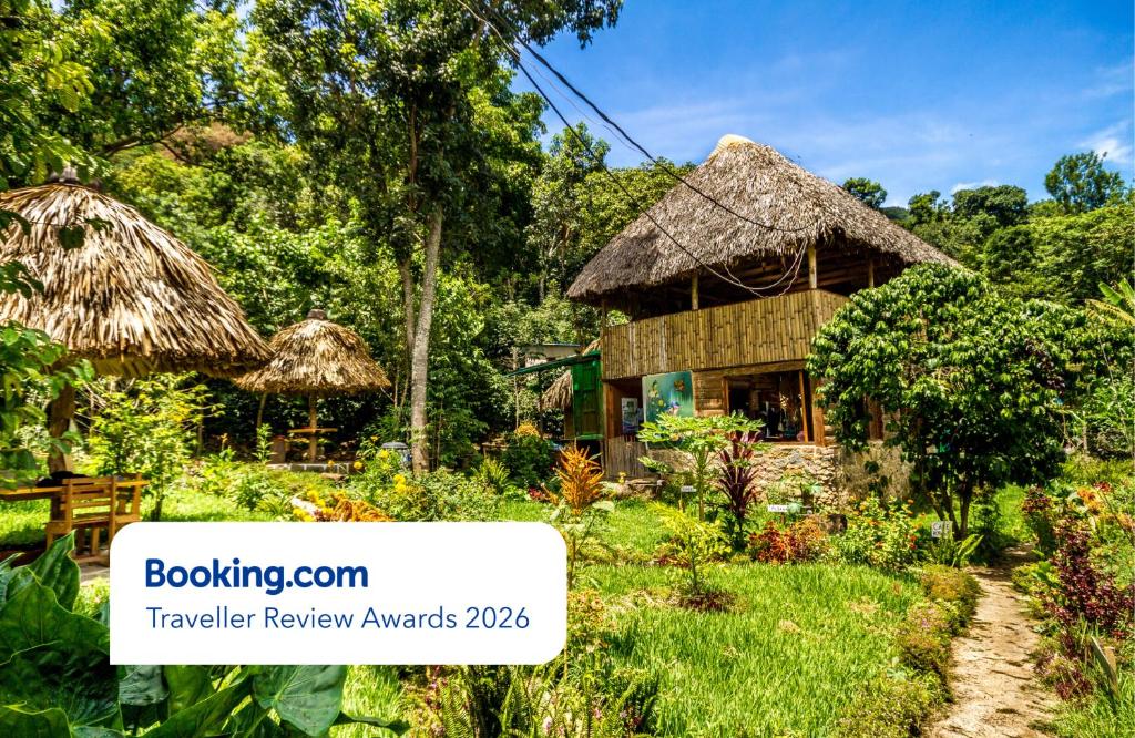 a house with a thatched roof in a garden at Eco-Hotel Mayachik in San Juan La Laguna