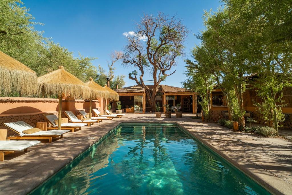 a swimming pool with lounge chairs and a resort at Awasi Atacama in San Pedro de Atacama