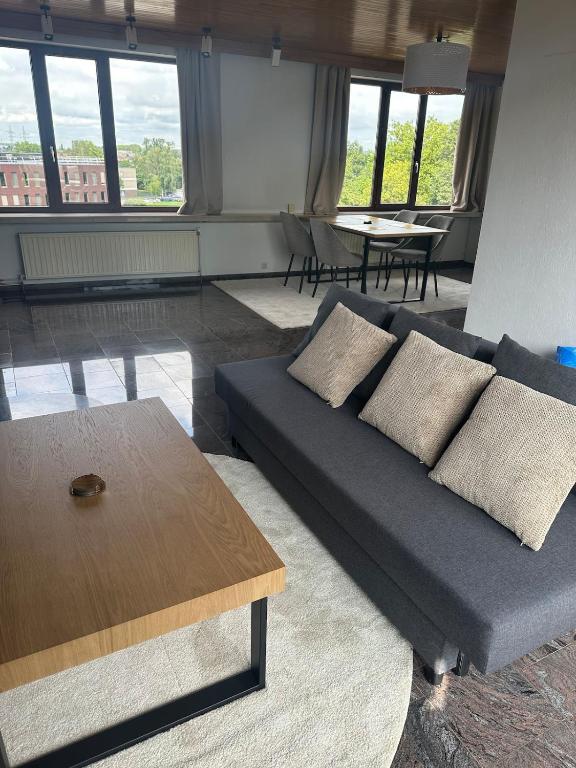a living room with a couch and a table at Antwerp West Side Penthouse in 't Hoeksken