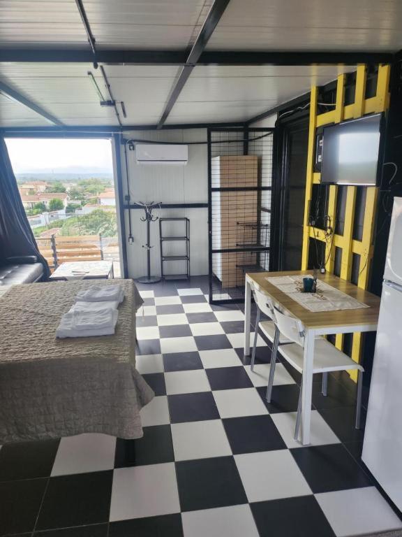 a room with a table and a checkered floor at Jim3 moterno studio fast wi-fi with a view in Andravída